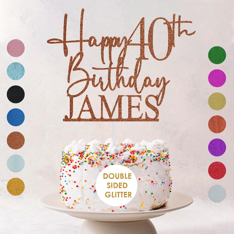 May include: A cake topper with the words "Happy 40th Birthday JAMES" in a glittery copper color. The cake is white with colorful sprinkles and sits on a white cake stand. The topper is double-sided glitter.