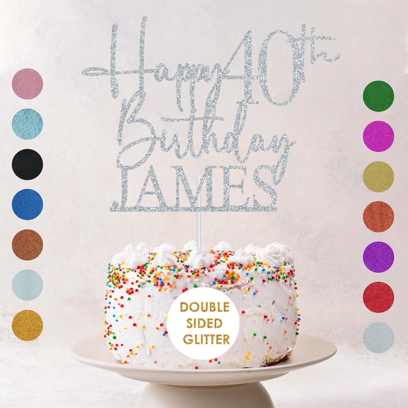 May include: A silver glitter cake topper that reads "Happy 40th Birthday JAMES". The topper is placed on top of a white frosted cake with colorful sprinkles. The words "Double Sided Glitter" are also visible.