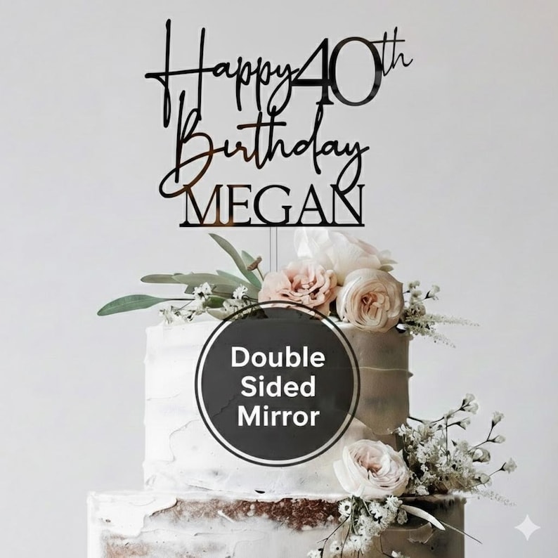 May include: A two-tiered cake with white frosting and floral decorations. A black acrylic cake topper reads "Happy 40th Birthday MEGAN". A round sticker on the cake says "Double Sided Mirror".