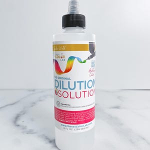 May include: A clear plastic bottle of dilution solution with a black cap and a dispensing tip. The label features the text "DILUTION SOLUTION" in red and a rainbow graphic. The bottle contains 8 fl oz (236.588 mL) of liquid.