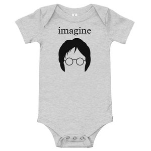 Puede incluir: Un body de bebé gris con texto negro que dice "imagine" y una silueta negra de la cara de John Lennon con gafas redondas.