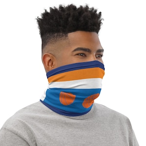 May include: A blue, white, and orange neck gaiter with basketball designs. The gaiter has a white stripe, an orange stripe, and a blue stripe.
