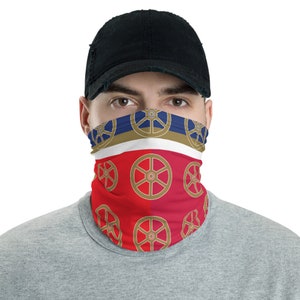 May include: A red and blue face mask with a white stripe and a gold wheel pattern. The mask is worn by a person with a black baseball cap.