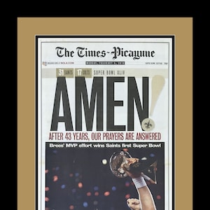 Puede incluir: Un titular de periódico en blanco y negro dice "¡AMÉN!" con el subtítulo "Después de 43 años, nuestras oraciones son respondidas." El titular está sobre una foto de un jugador de fútbol americano sosteniendo el trofeo del Super Bowl. El texto "Brees' MVP effort wins Saints first Super Bowl" está debajo de la foto.