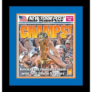 May include: A framed New York Post newspaper front page featuring the headline CHAMPS! and a photograph of basketball players holding a gold trophy. The text reads Knicks fans rejoice as team wins first title in 53 years, with a blue mat and black frame.