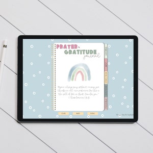 May include: A digital tablet displaying a digital planner with a watercolor rainbow design and the text "PRAYER, GRATITUDE journal". The planner has tabs for "COVER", "BODY", "EXTRA", "INFORMATION", "DAILY & WEEKLY", and "PRAYER & MEDITATION".