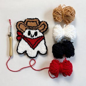 May include: A white ghost with a red bandana and a brown cowboy hat, along with six skeins of yarn in brown, white, black, and red.