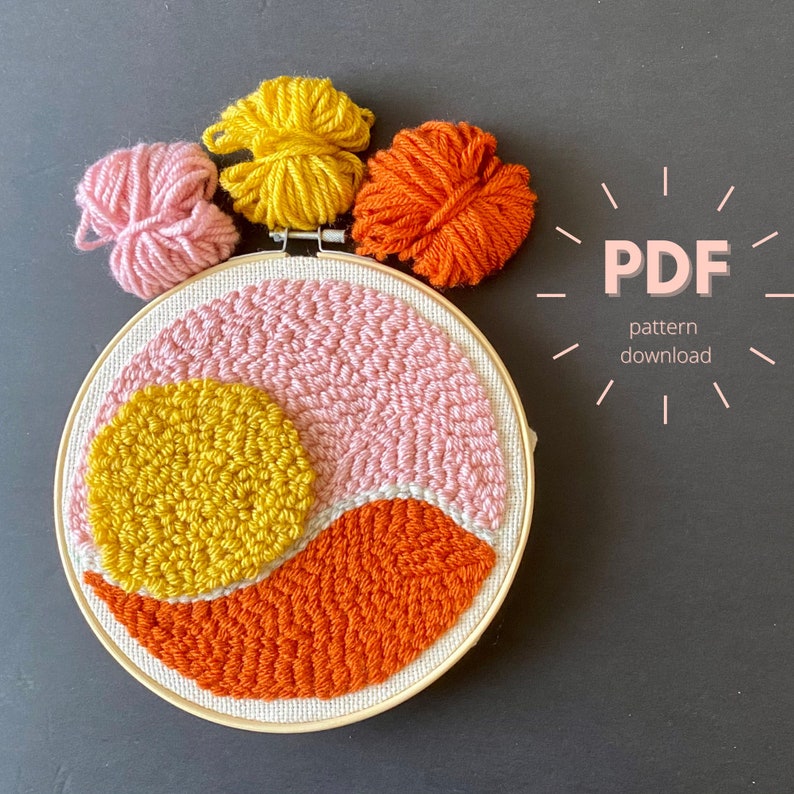 May include: A colorful abstract punch needle pattern with a pink, yellow, and orange color scheme. The pattern is in a hoop and is ready to be stitched. The text "PDF pattern download" is in the upper right corner of the image.
