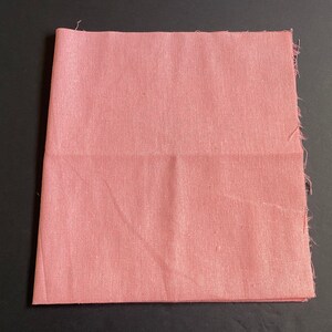 1 piece of 20 inch by 20 inch cotton linen fabric in pink color. It is folded in half and has raw edges.