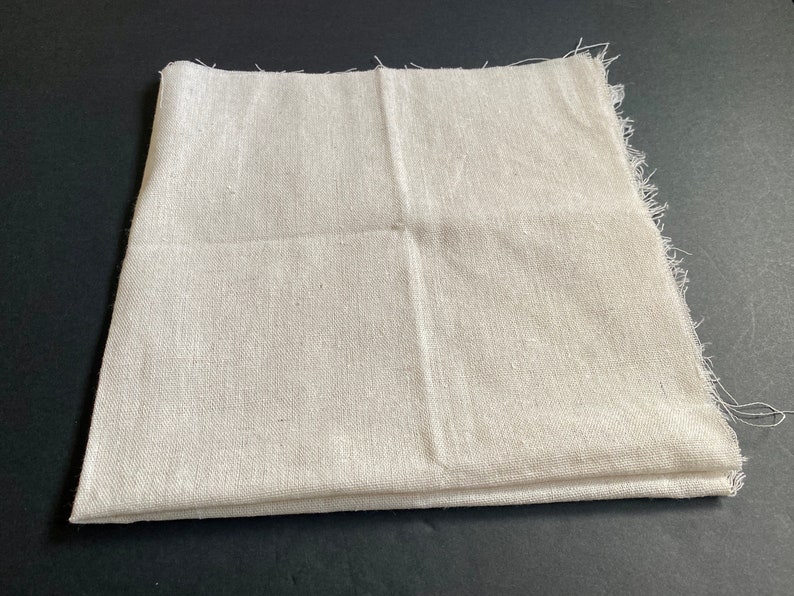 1 piece of 20 inch by 20 inch cotton linen fabric in off white. It is folded in half and has raw edges.