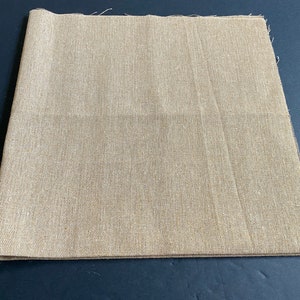 1 piece of 20 inch by 20 inch cotton linen fabric in khaki brown color. It is folded in half and has raw edges.