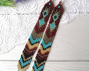 May include: Long, beaded earrings with a geometric pattern in shades of red, black, gold, and turquoise.