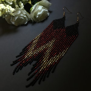 May include: Long black, red and gold beaded earrings with gold hooks.