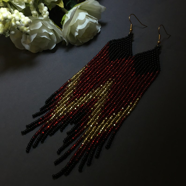 May include: Long black, red and gold beaded earrings with gold hooks.