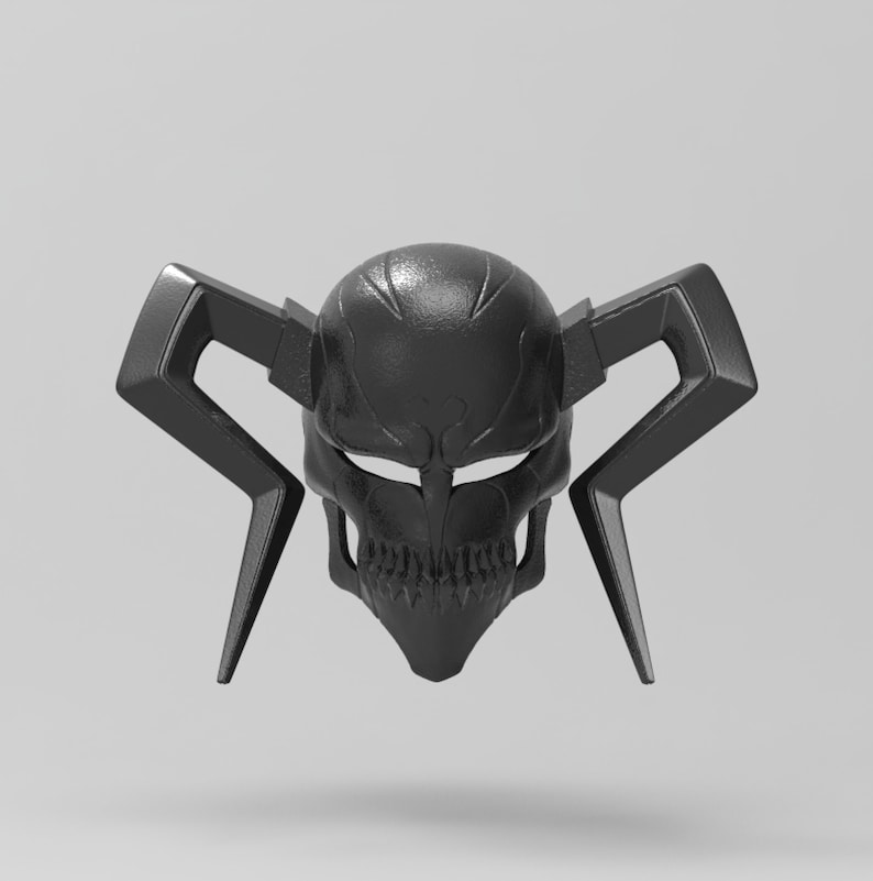 May include: A black skull mask with angular horns and a detailed facial design. The mask has a textured surface and is designed with open eye sockets and a detailed mouth. The mask is a dark, matte black color.
