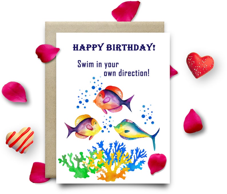 May include: Happy birthday card featuring a colourful watercolour illustration of three fish swimming in the ocean with coral reefs. The card reads "Happy Birthday! Swim in your own direction!"