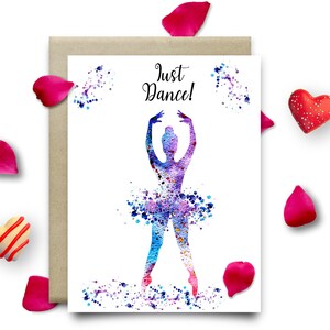 以下が含まれることがあります： 紫と青のチュチュを着たバレリーナの水彩画イラスト。上に「Just Dance!」の文字が印刷されています。