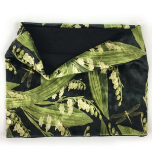 May include: Black velvet neck warmer with a green and white floral pattern featuring lily of the valley and dragonflies.