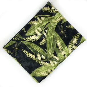 May include: A black velvet clutch bag with a floral print of lily of the valley and dragonflies. The flowers are in shades of green and white.