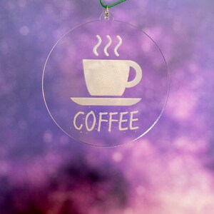 Peut inclure: Une boule ronde transparente avec une silhouette blanche d'une tasse de café et de la vapeur, et le mot "COFFEE" en dessous.