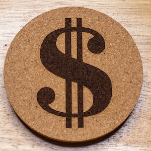 May include: A round cork coaster with a black dollar sign printed on it.