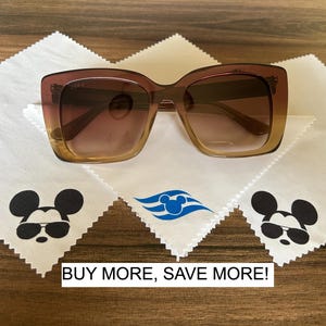 May include: Three white microfiber cleaning cloths with a blue and white cruise ship logo and a black and white Mickey Mouse wearing sunglasses design. The text "BUY MORE, SAVE MORE!" is printed below the cloths. A pair of brown sunglasses are on top of the cloths.