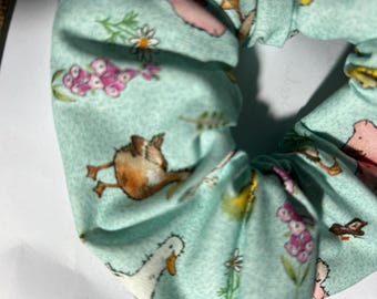 Coletero artesanal 100% algodón. Estampado de cerdito, patos y gansos sobre fondo azul verdoso.