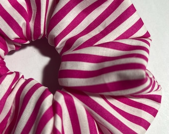 May include: A pink and white striped scrunchie made of fabric.