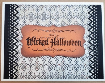 May include: Halloween greeting card with a decorative black border and a patterned background. The card features a brown label with the words "Have a Wicked Halloween" in a gothic font.