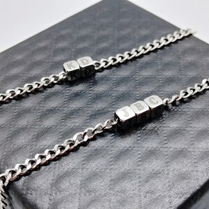 May include: Two silver chain bracelets with personalised letter charms. The first bracelet has the letters "KD" and the second bracelet has the letters "JBC".