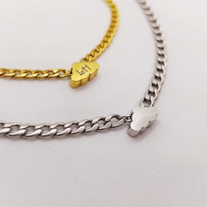 May include: Two gold and silver chain necklaces with cloud-shaped pendants. The gold pendant has the word "Left" engraved on it.