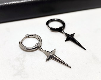 May include: Two hoop earrings with star-shaped pendants. One earring is silver-toned, the other is black. The star pendants have a pointed design. The earrings are displayed on a white surface.