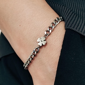 May include: A silver chain bracelet with a four-leaf clover charm.