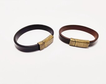 May include: Two leather bracelets with magnetic clasps. One bracelet is black and the other is brown.