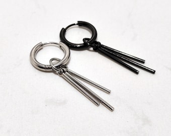 May include: Two hoop earrings, one silver-toned and one black, each with three dangling, slender bars. The earrings are displayed on a white surface, showcasing their minimalist design and contrasting colors. These earrings are suitable for everyday wear.