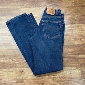 Könnte beinhalten: Eine blaue Jeans aus Denim mit einem braunen Leder-Levi's-Patch am hinteren Bund. Der Patch trägt das Levi's-Logo und den Text "Levi Strauss & Co. San Francisco, Calif. Original  Quality Clothing. W32 L32."