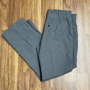 May include: A pair of grey straight-leg trousers with a back pocket.