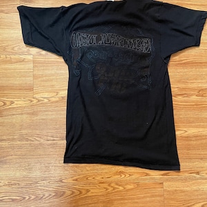 Puede incluir: Camiseta negra con un estampado gr&aacute;fico blanco de la banda "Grateful Dead" con el texto "1965-1995" y "The Grateful Dead" en la parte posterior.