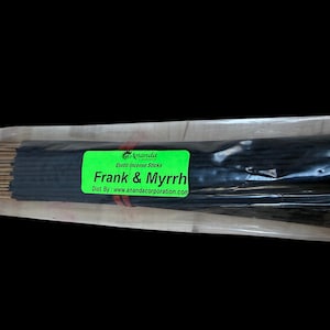 May include: A package of incense sticks with a green label that reads "Frank & Myrrh". The incense sticks are black and bundled together. The label also includes the brand name "Ananda" and the website address.