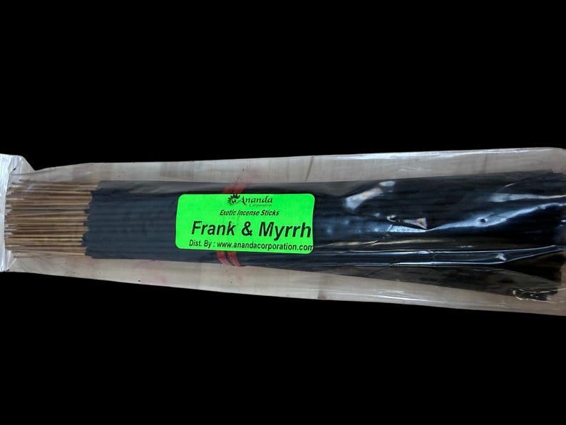 May include: A package of incense sticks with a green label that reads "Frank & Myrrh". The incense sticks are black and bundled together. The label also includes the brand name "Ananda" and the website address.