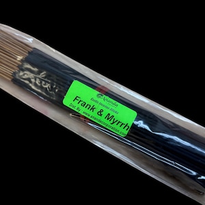 May include: A package of incense sticks with the text "Frank & Myrrh" on a green label. The incense sticks are dark in color with gold tips, and are packaged in a clear plastic bag.