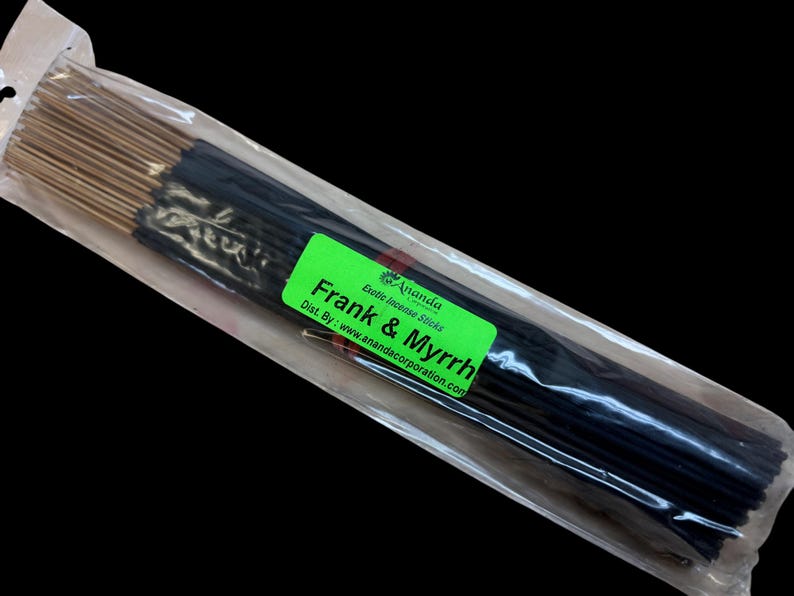 May include: A package of incense sticks with the text "Frank & Myrrh" on a green label. The incense sticks are dark in color with gold tips, and are packaged in a clear plastic bag.