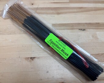 May include: A package of incense sticks with the label "Egyptian Musk." The sticks are dark, and the label is green with white text. The incense is packaged in clear plastic.