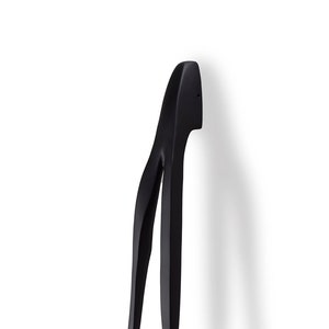 Puede incluir: Pomo de puerta negro ondulado con un diseño moderno y liso.