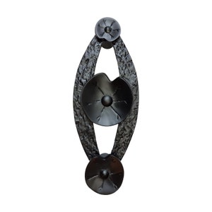 Puede incluir: Pomo de puerta de metal negro con tres detalles decorativos en forma de flor.
