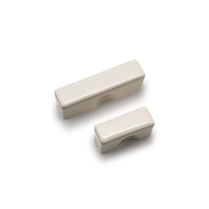 May include: Two off-white ceramic rectangular-shaped chopstick rests. The larger rest is in the background and the smaller rest is in the foreground.