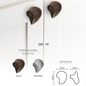 May include: A pair of cabinet knobs in bronze and satin nickel finishes. The knobs are shaped like a leaf and have a 3.5 inch (8.9 cm) projection. The text "GIK - 74" is visible in the image.