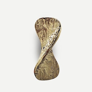May include: A gold-colored, abstract sculpture with a textured surface and a twisted, elongated shape. The sculpture has a rough, organic texture on the lower half and a smooth, polished finish on the upper half.