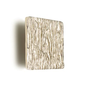 May include: A square, textured, gold-toned metal cabinet knob.