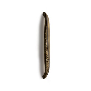May include: A long, curved, antique gold door handle with a textured surface.